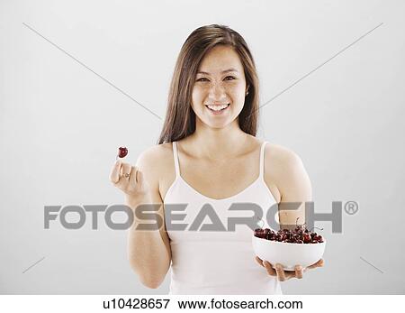 Stock Photo - Woman holding a bowl of cherries. Fotosearch