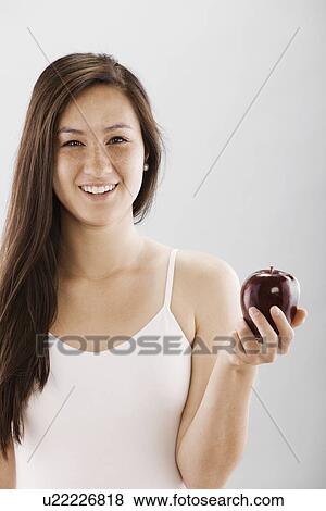 Woman holding a red apple View Large Photo Image Stock Photo - Woman holding a red apple. Fotosearch