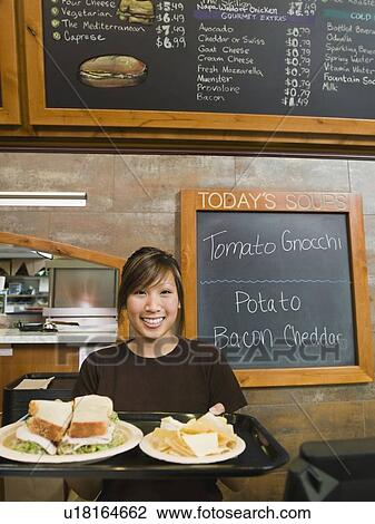 Woman holding tray of food in bakery View Large Photo Image Stock Image - Woman holding tray of food in bakery. Fotosearch