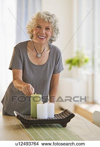 Picture - Woman lighting candles. Fotosearch