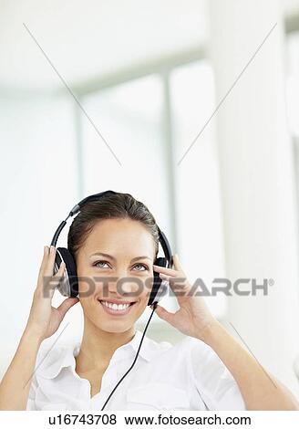 Woman listening to music on headphones View Large Photo Image Stock Photo - Woman listening to music on headphones. Fotosearch