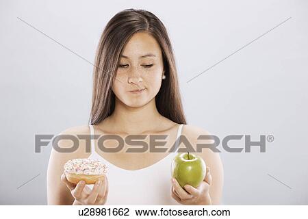 Stock Image - Woman making food choice. Fotosearch