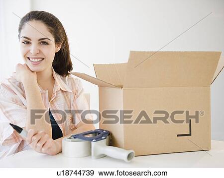 Stock Photo - Woman packing boxes. Fotosearch