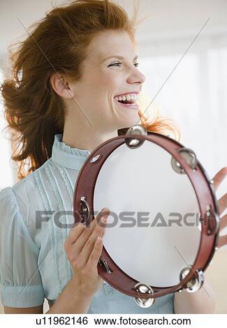 Stock Photograph - Woman playing tambourine. Fotosearch