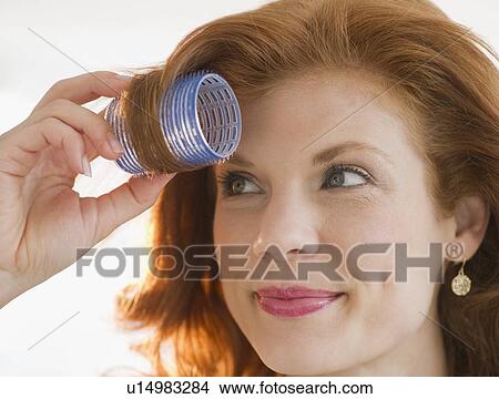 Woman putting curler in her hair View Large Photo Image Picture - Woman putting curler in her hair. Fotosearch