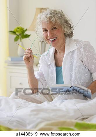 Woman reading a book in bedroom View Large Photo Image Stock Photo - Woman reading a book in bedroom. Fotosearch