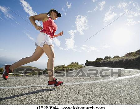 Picture - Woman running on a road in Malibu. Fotosearch
