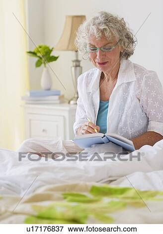 Stock Photo - Woman writing in her journal. Fotosearch