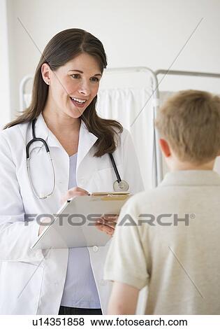 Young boy and doctor in examination room View Large Photo Image Stock Photo - Young boy and doctor in examination room. Fotosearch