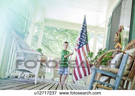 Stock Photo - Young boy carrying American flag. Fotosearch