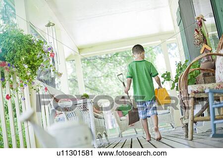 Young boy carrying shovel and tool box on porch View Large Photo Image Stock Image - Young boy carrying shovel and tool box on porch. Fotosearch