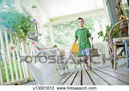 Young boy carrying shovel and tool box on porch View Large Photo Image Stock Image - Young boy carrying shovel and tool box on porch. Fotosearch