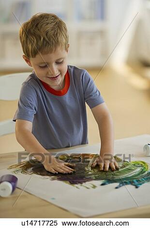 Stock Photography - Young boy finger painting. Fotosearch
