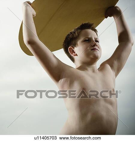 Young boy holding a surfboard over his head View Large Photo Image Stock Image - Young boy holding a surfboard over his head. Fotosearch