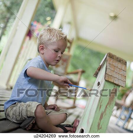 Stock Photo - Young boy painting a birdhouse. Fotosearch