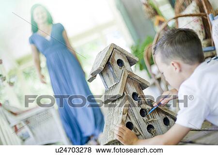 Stock Photo - Young boy painting a birdhouse. Fotosearch