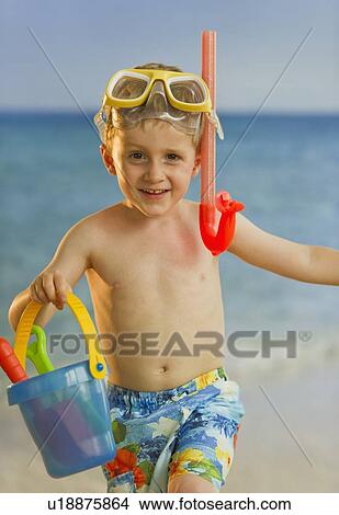 Young boy playing at the beach View Large Photo Image Picture - Young boy playing at the beach. Fotosearch