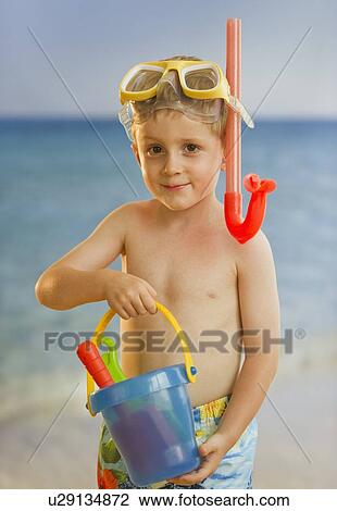 Stock Image - Young boy playing at the beach. Fotosearch