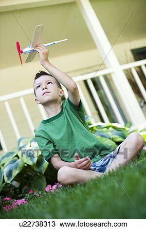 Young boy playing with toy airplane View Large Photo Image Stock Image - Young boy playing with toy airplane. Fotosearch