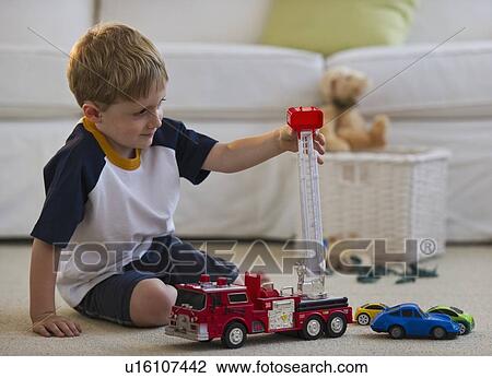 Young boy playing with toy fire truck View Large Photo Image Stock Image - Young boy playing with toy fire truck. Fotosearch