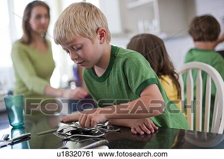 Young boy setting the table View Large Photo Image Stock Image - Young boy setting the table. Fotosearch