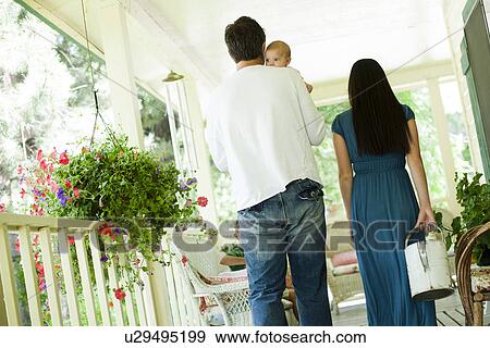 Stock Photo - Young family walking on porch. Fotosearch