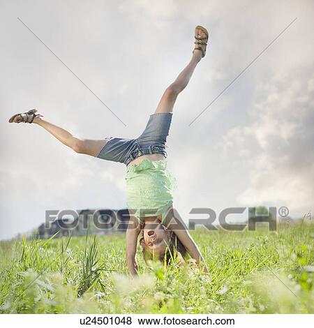 Stock Photo - Young girl doing cartwheel. Fotosearch