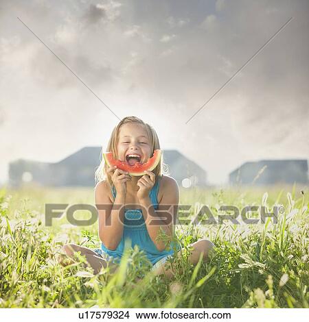 Picture - Young girl eating a slice of watermelon. Fotosearch