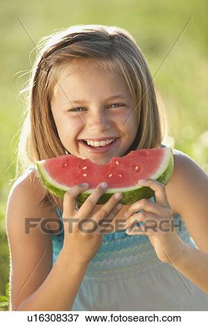 Young girl eating a slice of watermelon View Large Photo Image Stock Photo - Young girl eating a slice of watermelon. Fotosearch