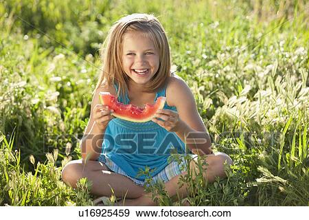 Young girl eating a slice of watermelon View Large Photo Image Stock Photo - Young girl eating a slice of watermelon. Fotosearch