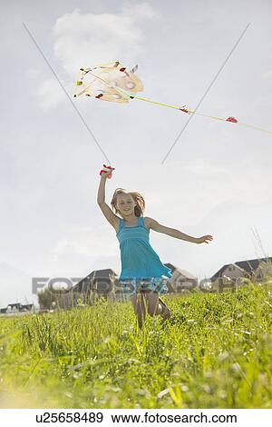 Stock Photo - Young girl flying a kite. Fotosearch