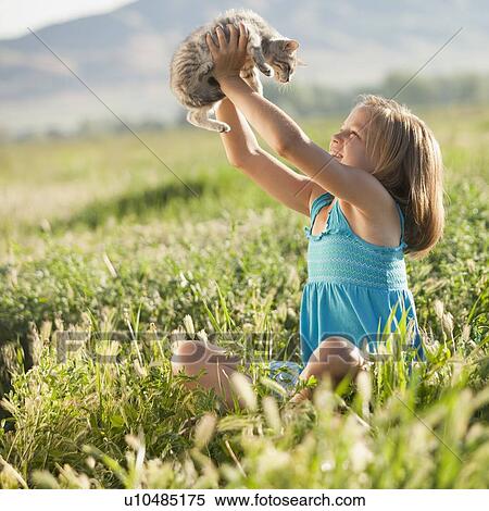 Stock Photography - Young girl holding a kitten. Fotosearch
