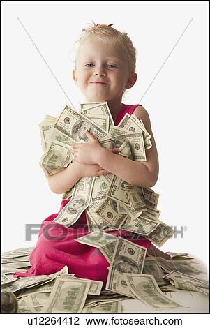 Stock Image - Young girl holding a pile of money. Fotosearch