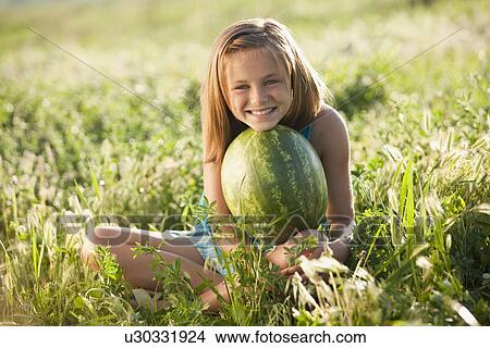 Young girl holding a watermelon View Large Photo Image Picture - Young girl holding a watermelon. Fotosearch