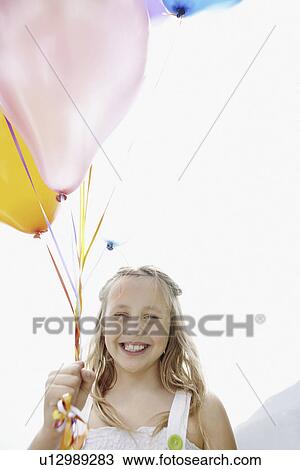 Young girl holding balloons View Large Photo Image Stock Image - Young girl holding balloons. Fotosearch