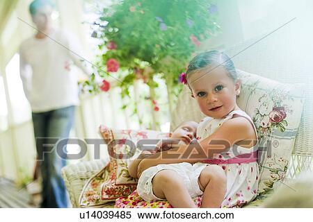 Stock Photography - Young girl holding her baby sister. Fotosearch