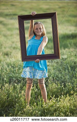 Stock Photo - Young girl holding picture frame. Fotosearch
