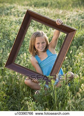 Young girl holding picture frame View Large Photo Image Stock Photograph - Young girl holding picture frame. Fotosearch