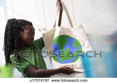Stock Photo - Young girl holding reusable shopping bag. Fotosearch