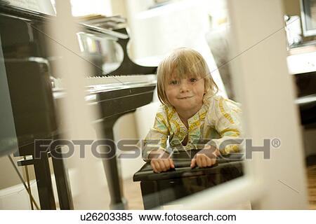 Stock Photography - Young girl lying on piano bench. Fotosearch