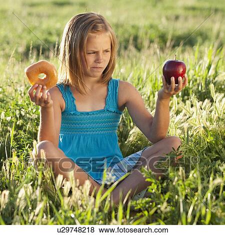 Stock Photo - Young girl making food choice. Fotosearch