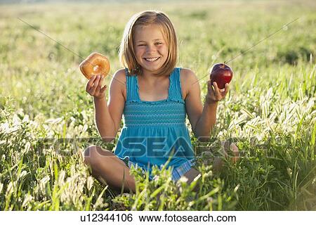 Stock Photograph - Young girl making food choice. Fotosearch