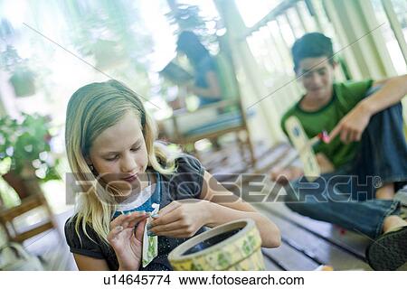 Young girl opening a seed packet View Large Photo Image Picture - Young girl opening a seed packet. Fotosearch