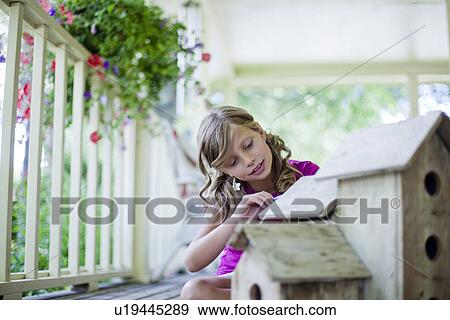 Stock Photo - Young girl painting a birdhouse. Fotosearch