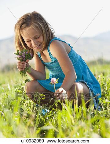 Stock Photo - Young girl picking clover. Fotosearch