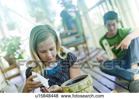 Young girl planting seeds in a planter View Large Photo Image Stock Photo - Young girl planting seeds in a planter. Fotosearch