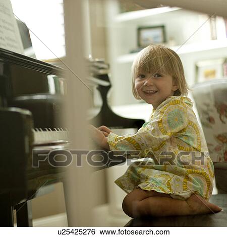 Stock Photograph - Young girl playing piano. Fotosearch