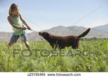 Stock Photography - Young girl playing with dog. Fotosearch