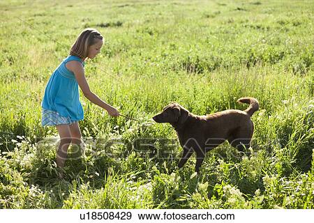 Stock Photo - Young girl playing with her dog. Fotosearch