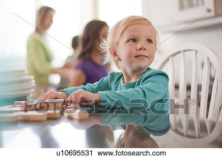 Stock Image - Young girl playing with wooden blocks. Fotosearch